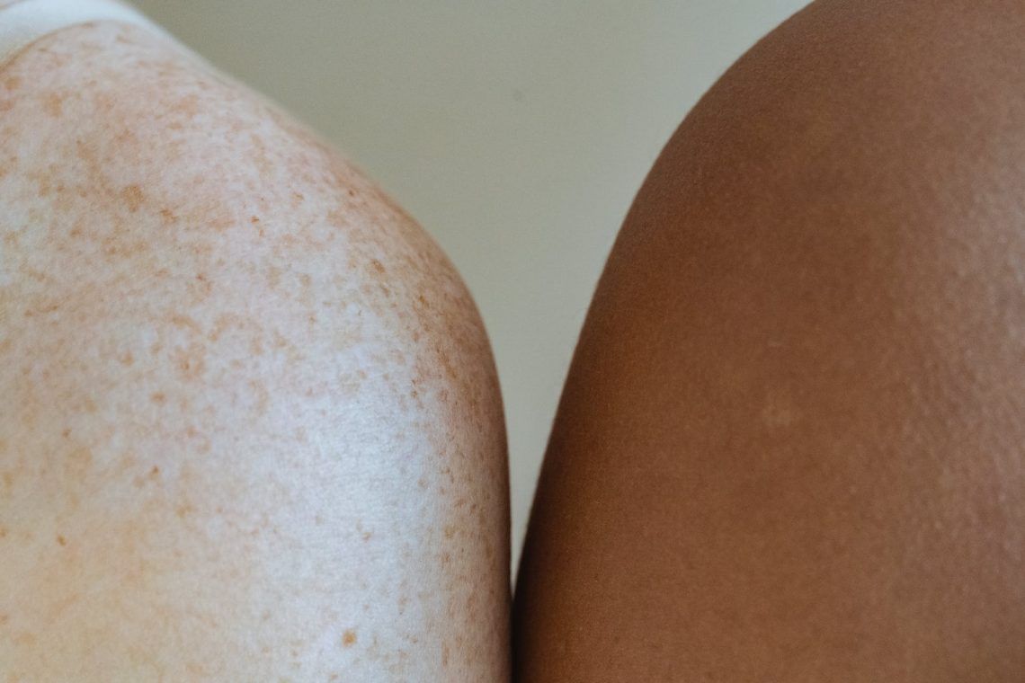 shoulders of multiracial models against light wall