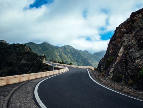 black asphalt road near cliff mountain