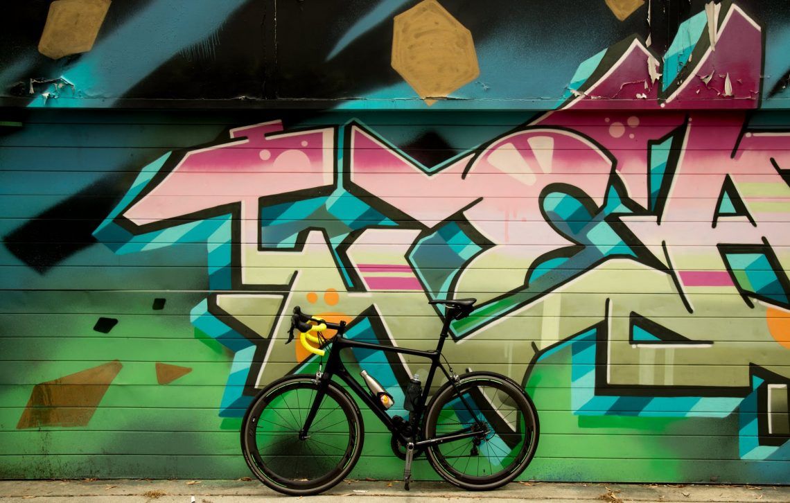 bicycle standing next to a graffiti wall