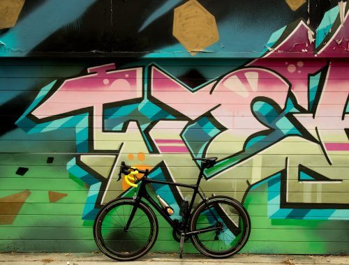 bicycle standing next to a graffiti wall