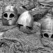 grayscale photography of chainmails and helmets on ground