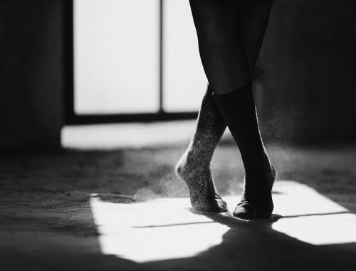 crop ballerina silhouette dancing on floor with shadow